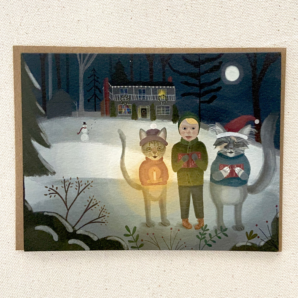Christmas card of a boy with two cats singing in a snowy landscape at night.