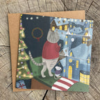 Holiday greeting card with a cat and mouse looking out a window at a snowy city scene.