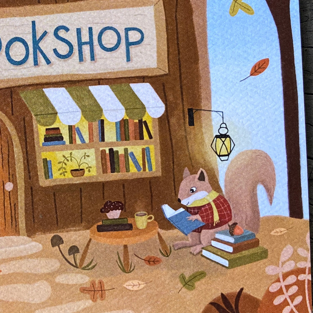 A cozy illustrated bookshop storefront with a squirrel sitting by the window reading a blue book, surrounded by books, leaves, a mug, and autumn details. The sign above the shop reads "BOOKSHOP".