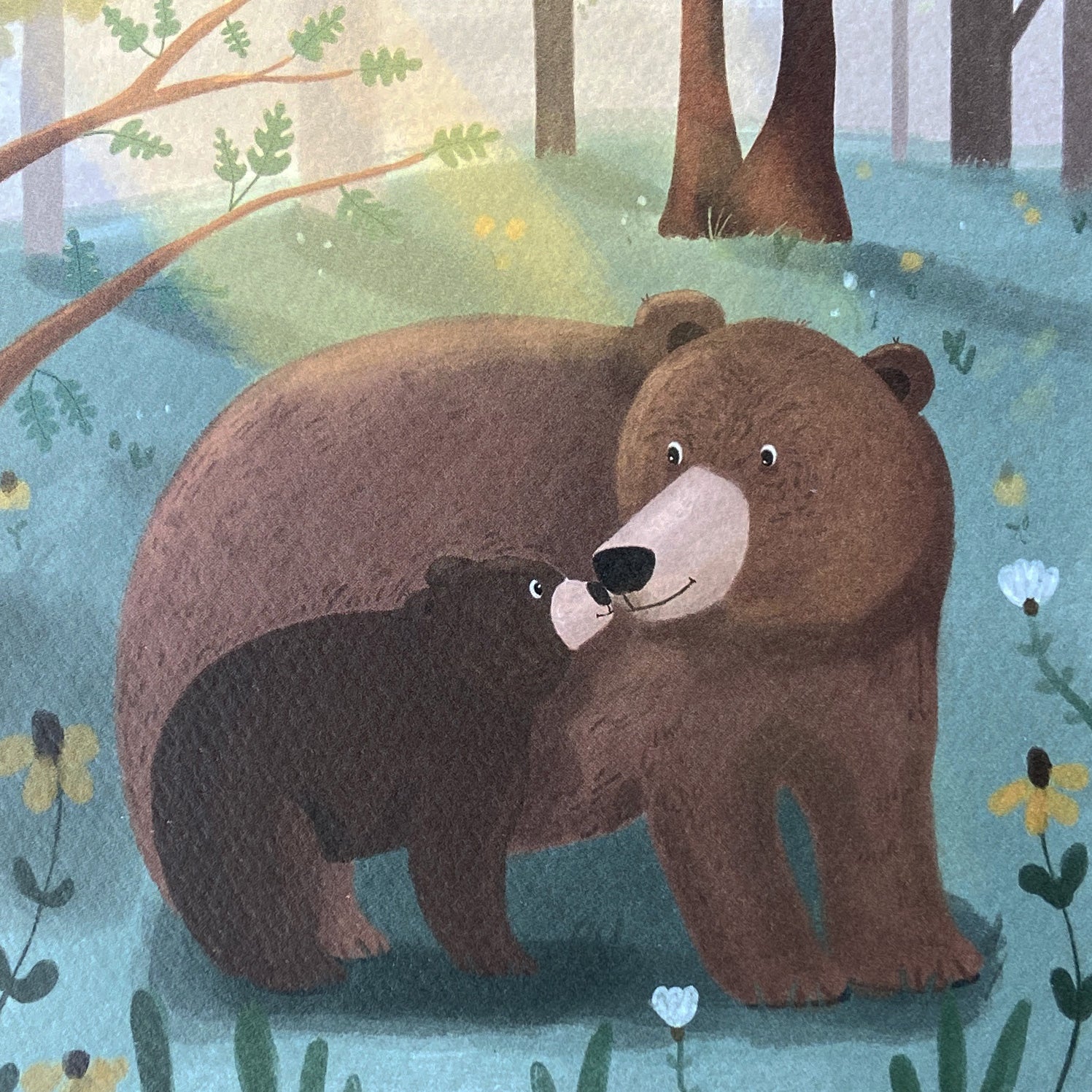 Close up of a greeting card featuring two bears in a forest setting with flowers and trees.
