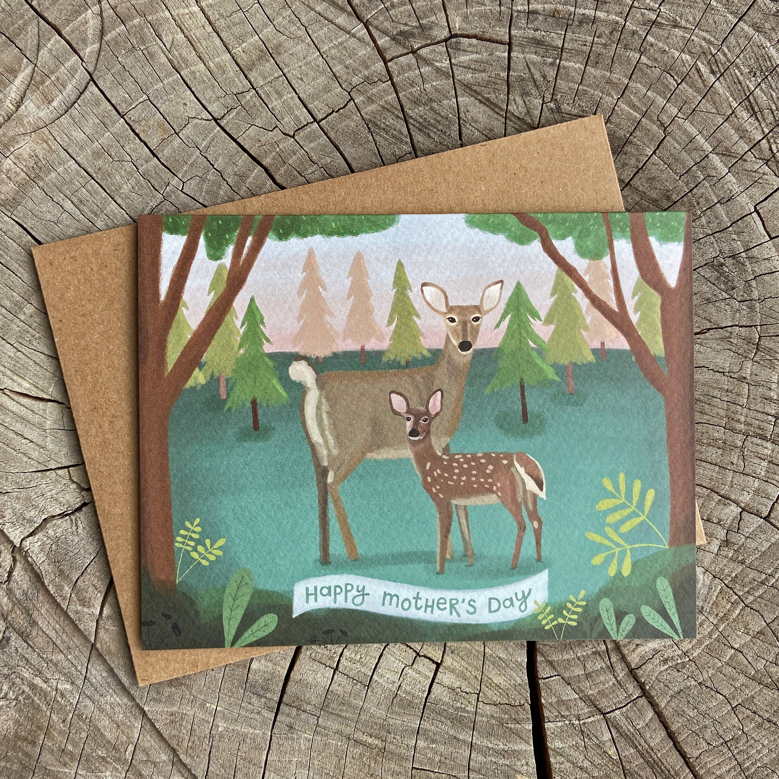 Mother's Day card with deer illustration on a wooden surface
