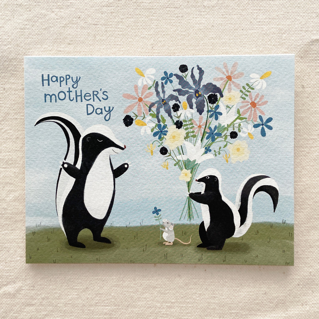Mother's Day card with two skunks holding a bouquet of flowers on a grassy field with a cream background