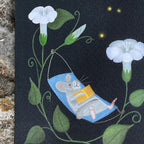 Close up illustration of a greeting card featuring a mouse relaxing in a hammock looking at fireflies surrounded by moonflowers and leaves on a dark background.