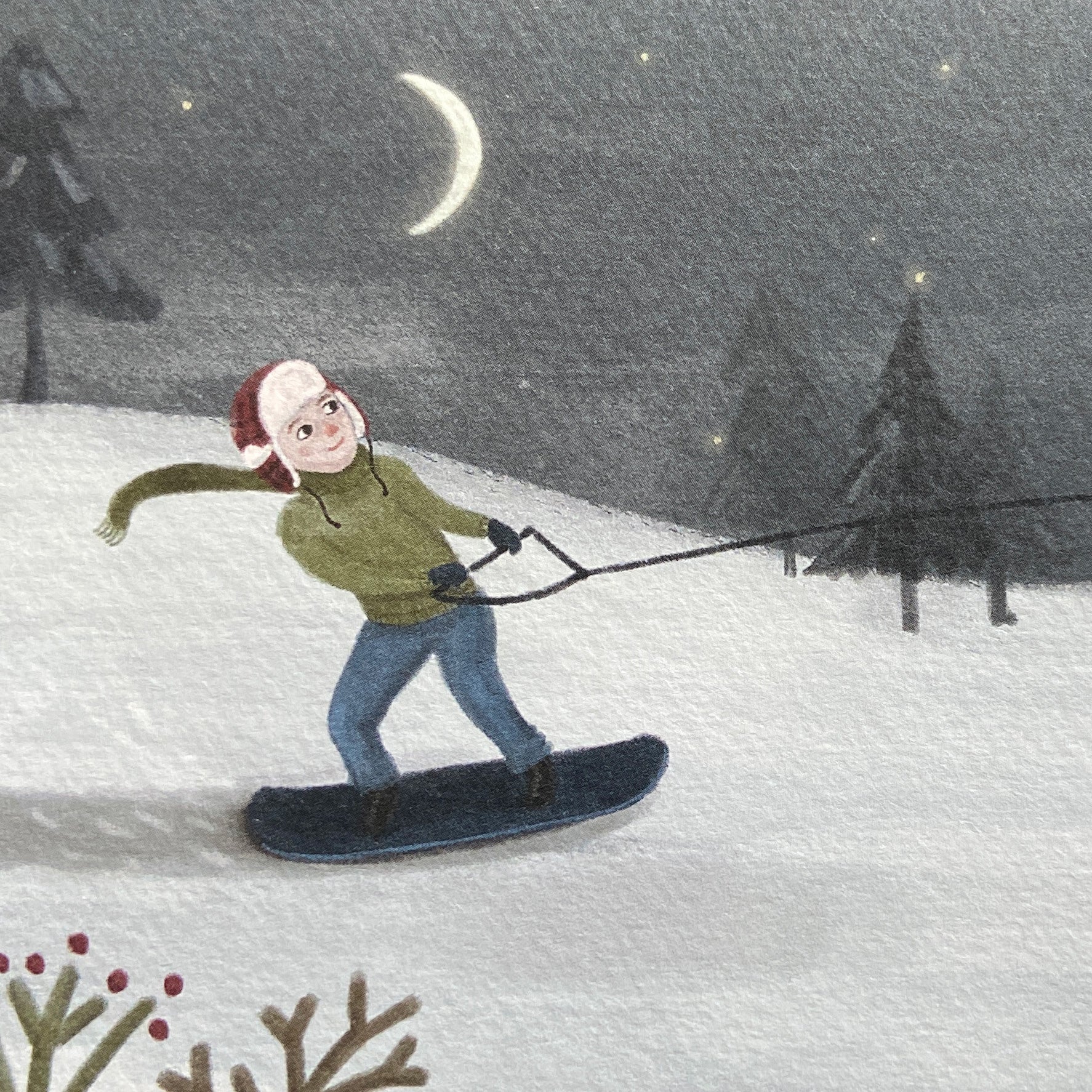 Close up illustration of a greeting card featuring a person snowboarding through a snowy landscape with an owl and crescent moon in the sky.