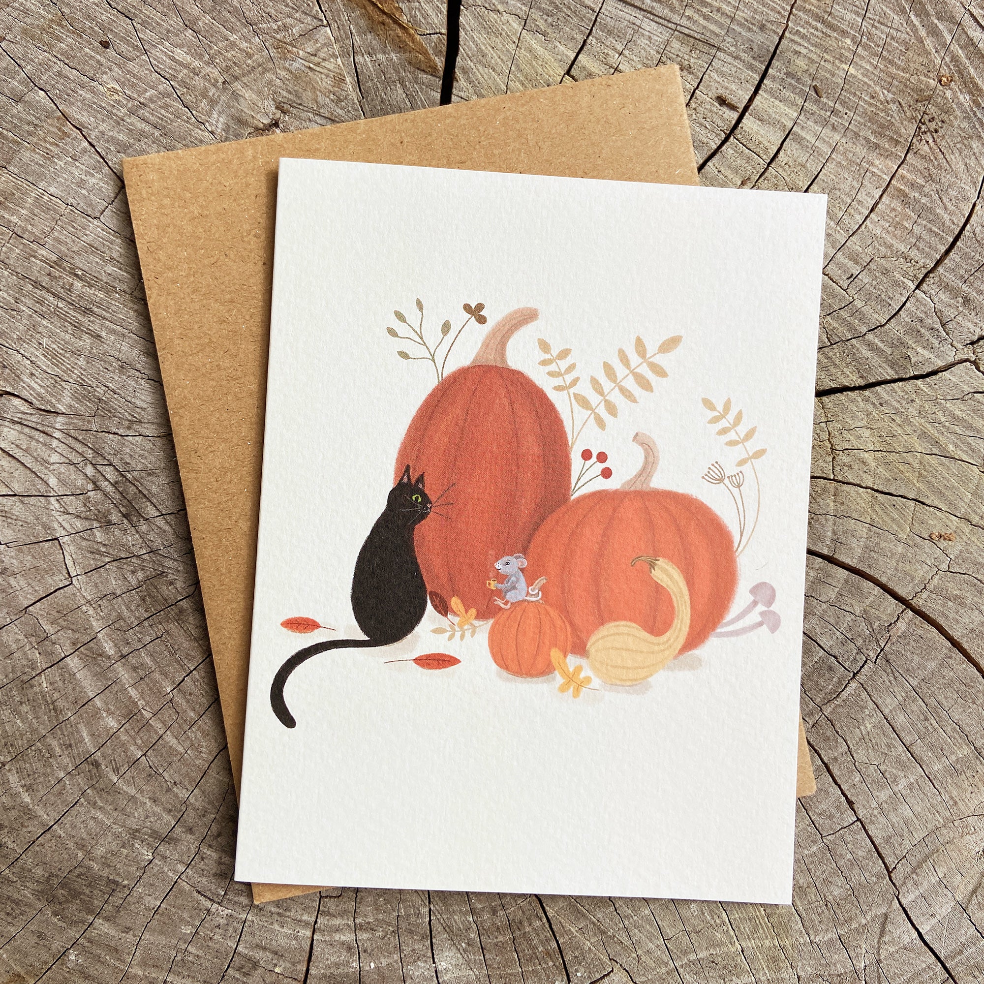 Magicial greeting card with pumpkins, a black cat and a mouse drinking coffee