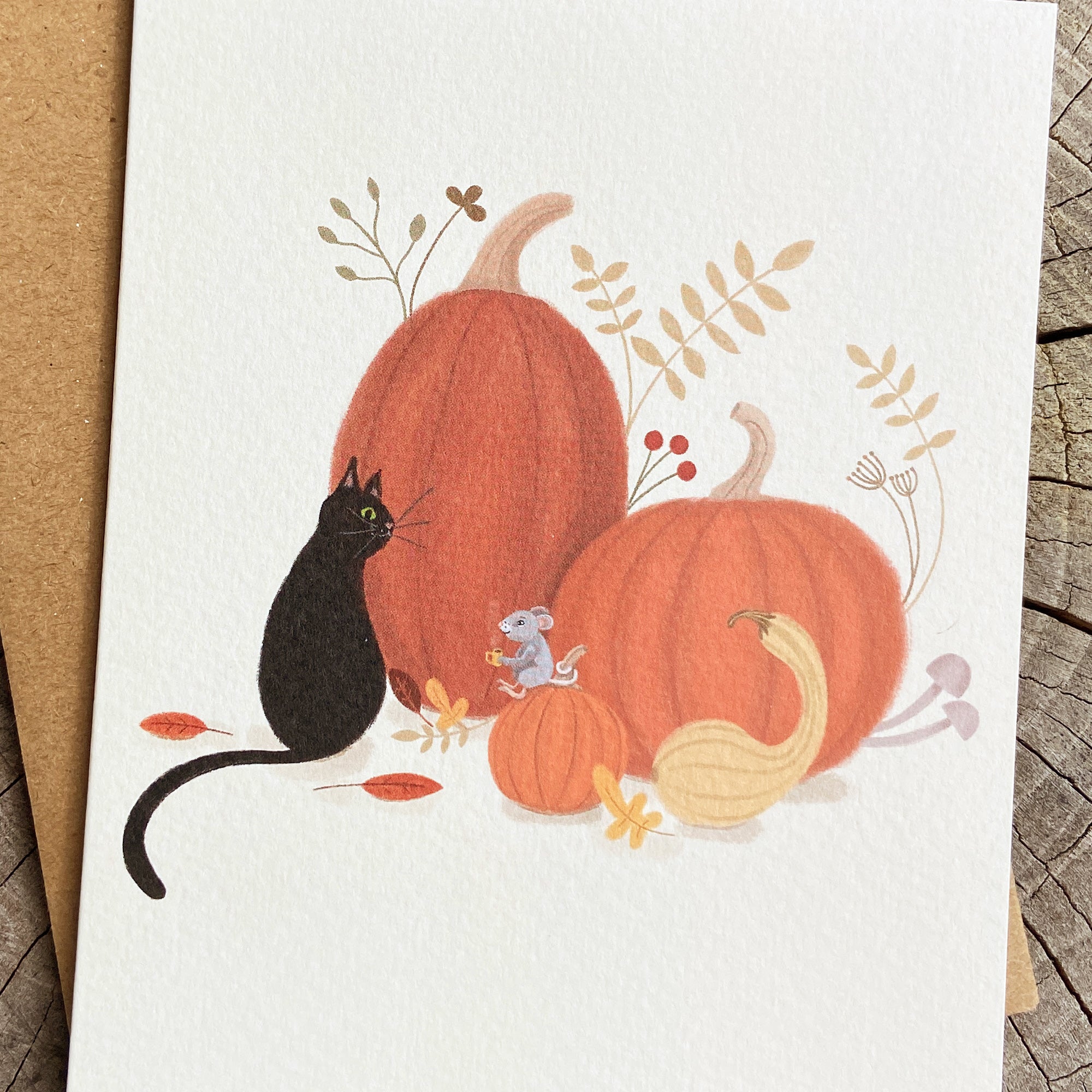 Fall greeting card of a black cat, mouse, and pumpkins on a cream background