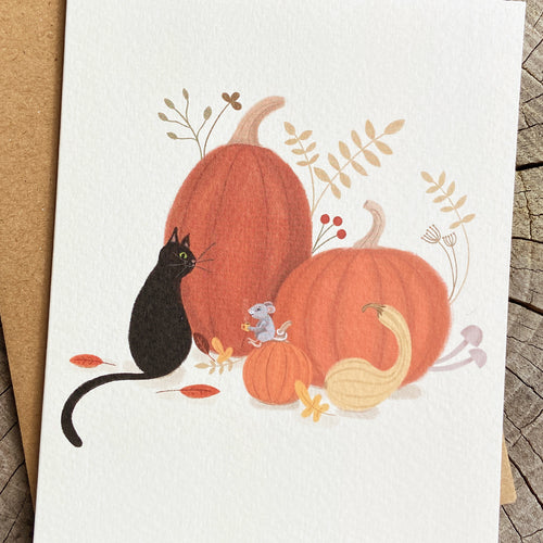 Fall greeting card of a black cat, mouse, and pumpkins on a cream background