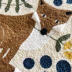 Close-up of a textured fabric art piece with a fox design and floral elements.