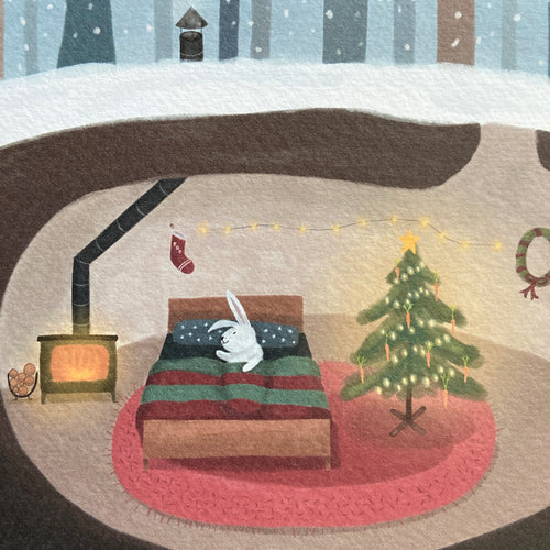 Close up Christmas card illustration of a rabbit's cozy living room with a Christmas tree, fireplace, and stockings.
