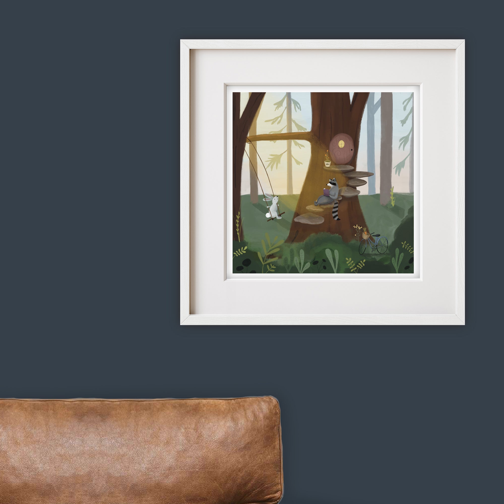 Framed illustration of a forest scene with woodland animals on a dark blue wall.