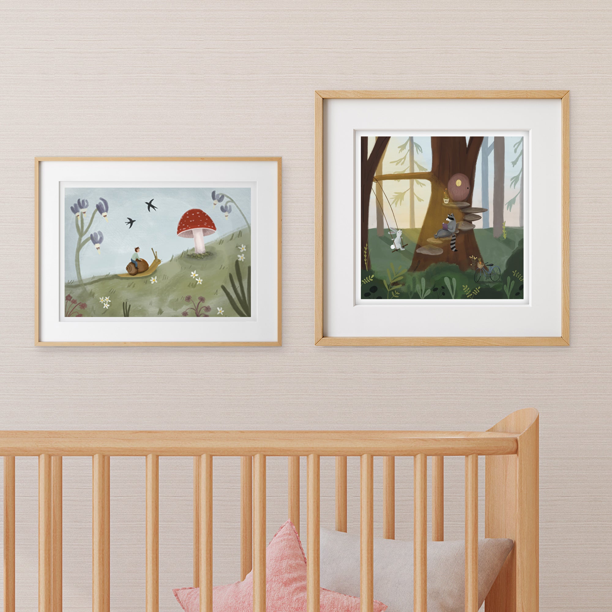 Two framed forest themed illustrations on a wall above a crib in a woodland creature nursery.