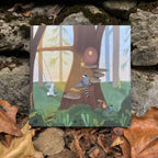 Illustrated card with woodland animals around a treehouse, on a stone surface with leaves. 