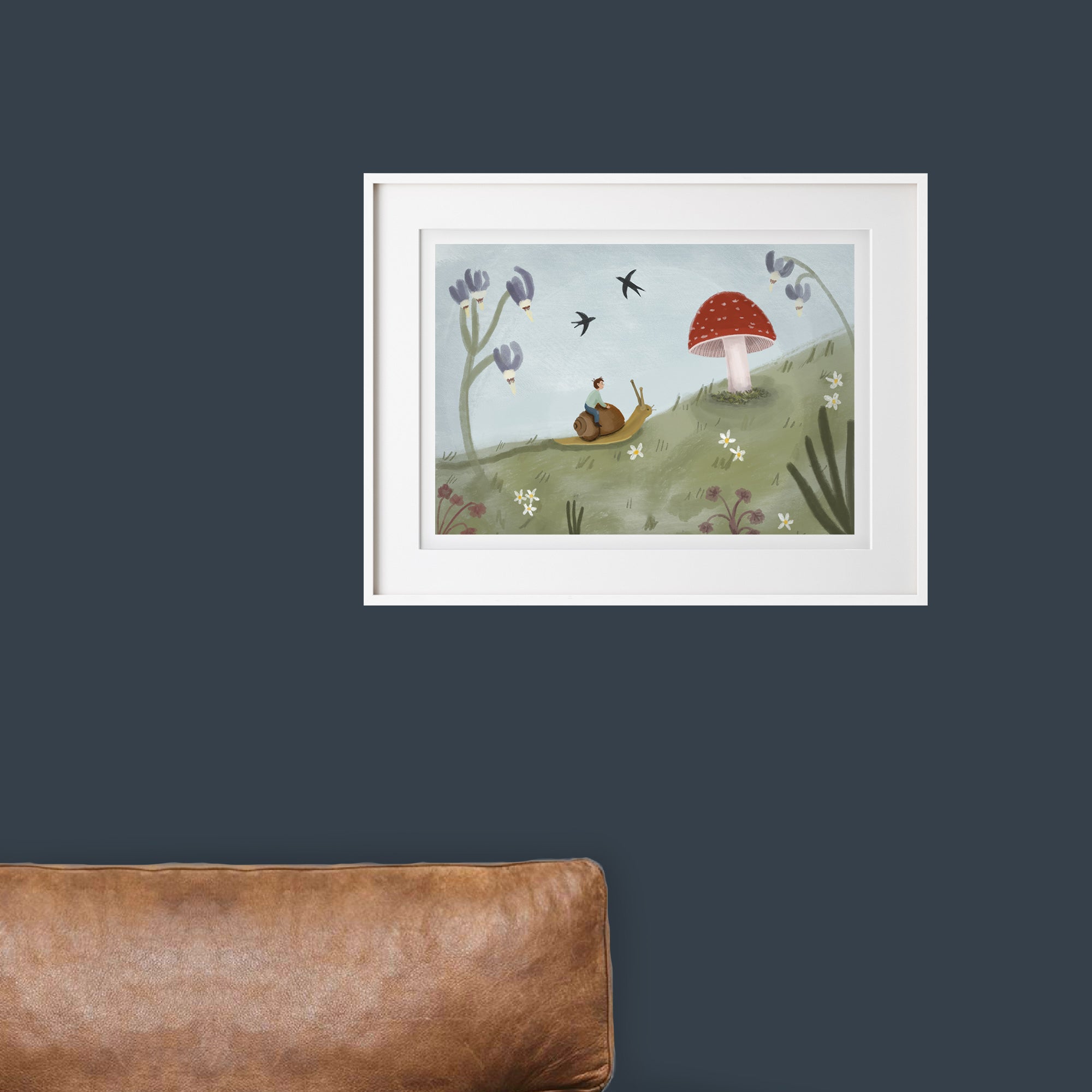 Framed illustration of a snail on a mushroom with flowers and birds against a dark blue wall.