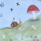 Close up of a greeting card featuring a child riding a snail on a grassy hill with a mushroom and flowers, under a blue sky with birds.