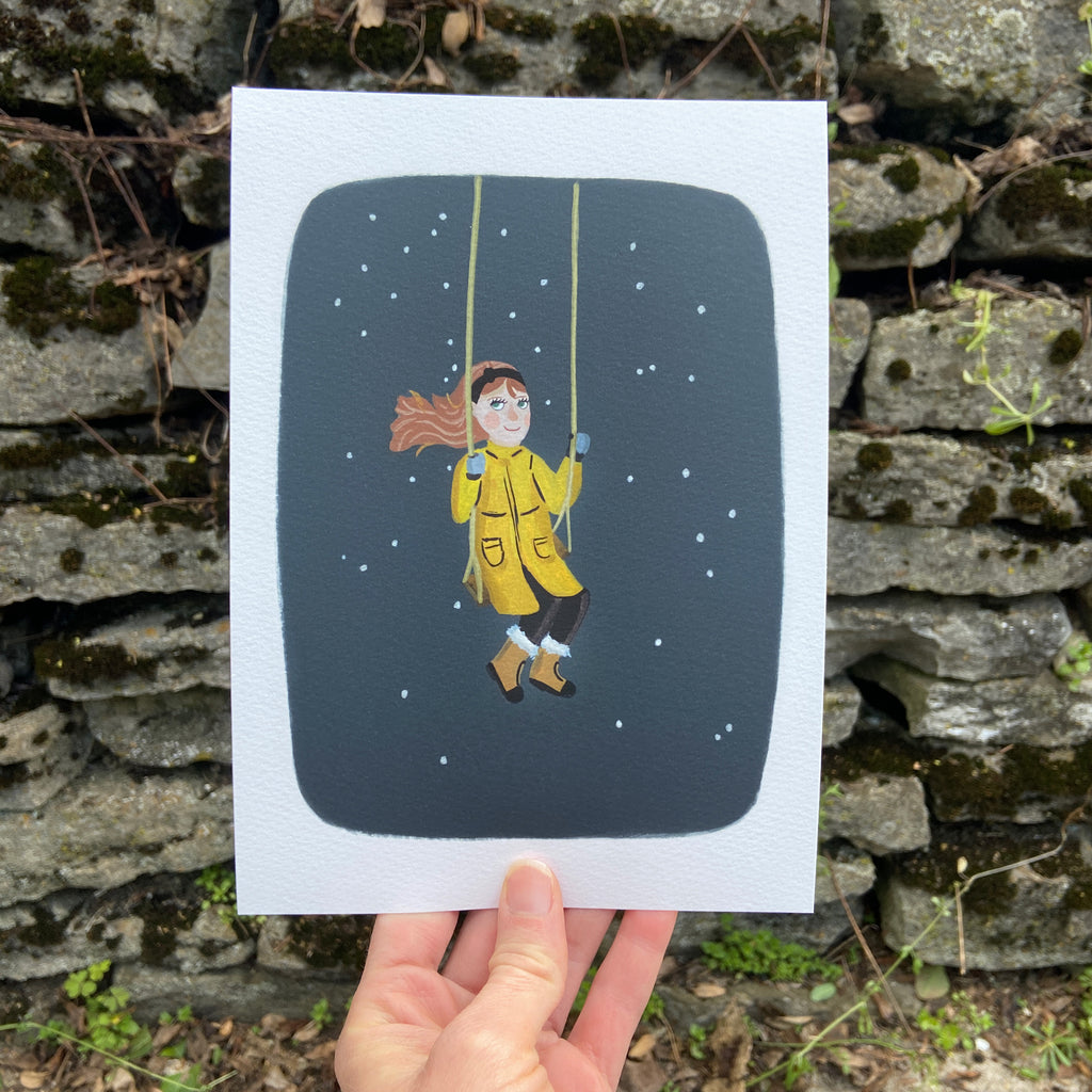 Art print of a person in a yellow raincoat on a swing held against a stone wall.