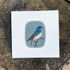 Art print with a bird illustration on a wooden surface