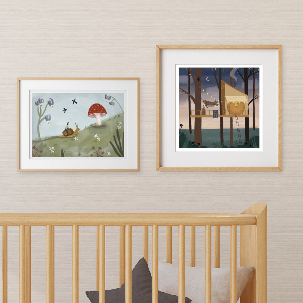 Two framed nursery artworks above a crib with a neutral wall background