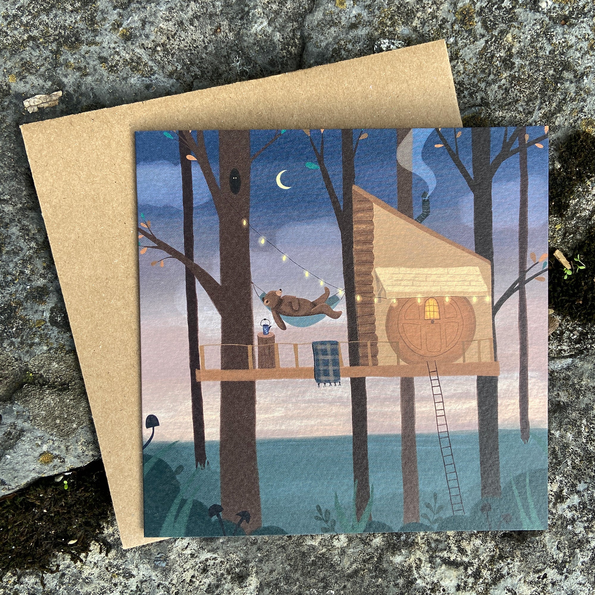 Greeting card with a bear treehouse illustration on a textured stone background