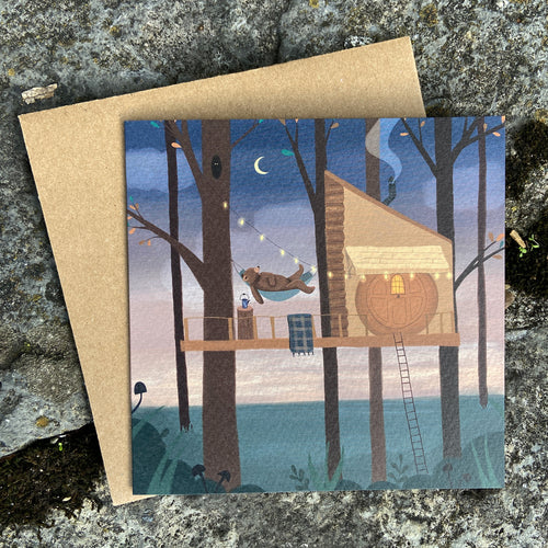 Greeting card with a bear treehouse illustration on a textured stone background