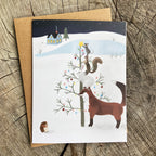 Holiday card with winter scene featuring woodland animals decorating a tree
